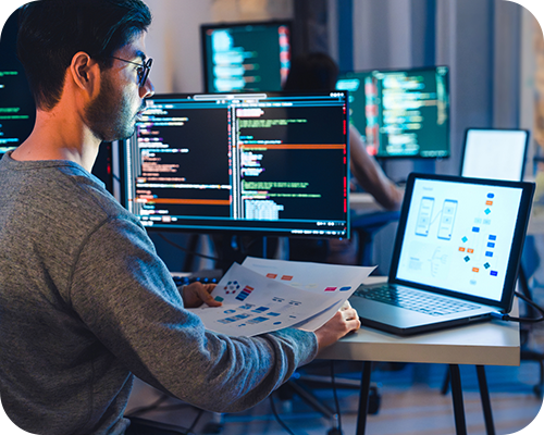 A person in a dim office views code on a monitor