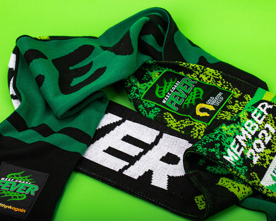 A close-up of a green knitted west coast fever scarf