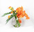 Moon vase with orange cymbidiums and mango callas