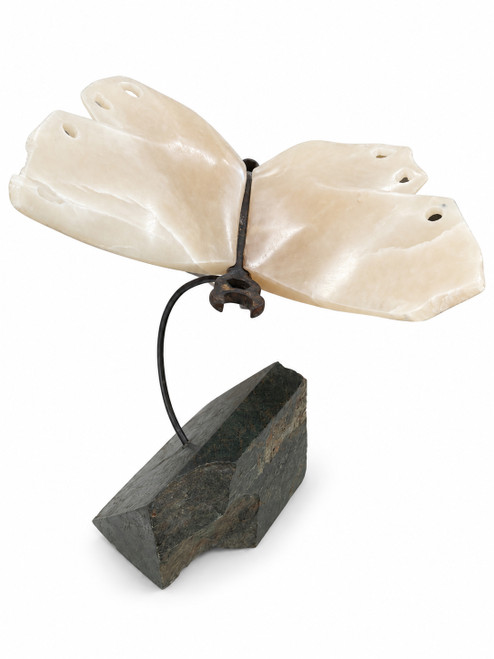 Three-quarter studio view of contemporary mixed-media sculpture 'Metamorphosis' featuring white translucent agate butterfly wings clamped by an old iron wrench on a green marble base by Rebecca Robinson