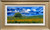 Wide horizontal impressionist oil landscape painting of a yellow field and single tree under a dramatic blue and white cloudy sky by Dan Harkins