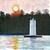 Square oil painting of a white lighthouse under a large glowing sun and a red autumn tree by Sally Bourdon.