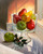 Hyperrealistic still life oil painting of red pears and green apples in a glass bowl on a windowsill by Elouise Lane Quadros.