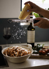 Bottle of seriously old dirt red wine next to a bowl of pasta