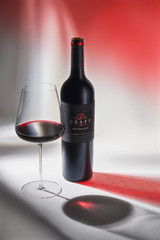 Bottle of Delaire Graff Botmaskop, Stellenbosch 2020 red wine with dark fruit and oak flavors. Bottle of wine next to glass of red wine.