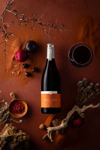 Rickety Bridge Regna Loca Cinsault 2024 South African red wine bottle with fruit and glass of wine flat lay styling