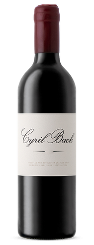 Bottle of Fairview 'Cyril Back' Shiraz, Coastal Region 2017, red wine with notes of blackberry, plum, spice and oak. Bottle of wine next to glass of red wine and decanter.