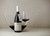 Bottle of Uva Mira Mountain Vineyards 'D.W.' Syrah 2021 from Helderberg, with cherries, pepper and wild fynbos. Bottle of wine next to carafe and glass of red wine.