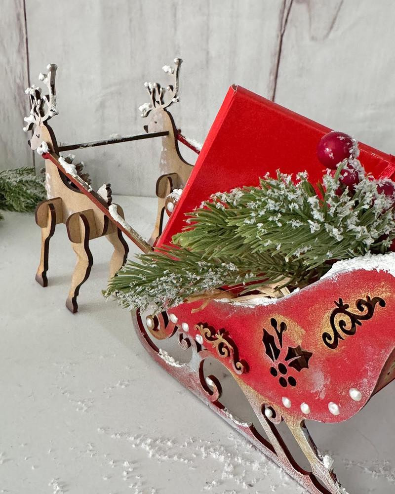 MDF 3D Santa's Reindeer Sleigh MDF blank Craft Kit – Christmas Holiday Home Décor crafts, decorative red Christmas sleigh with festive holly and snow accents, accompanied by reindeer figures, suitable for holiday decoration projects.