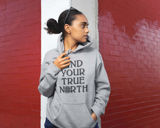 Young woman wearing a sport grey hoodie with Find Your True North design.