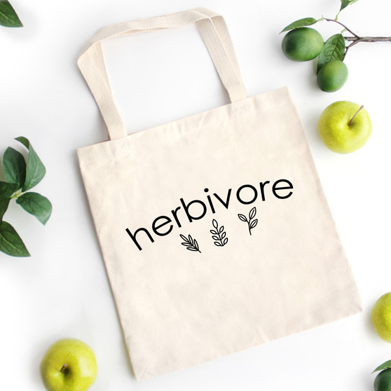 Natural canvas vegan tote with the word herbivore and plants printed on it.