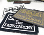 Smash the patriarchy feminist iron on patch in various colors.