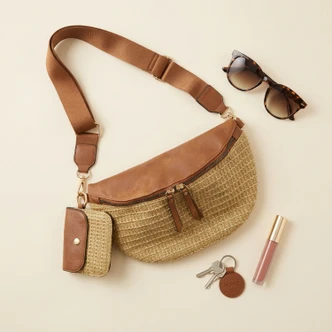 Brown leather and straw woven crossbody bag with matching pouch, sunglasses, keys and lip gloss flat lay