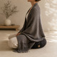 Charcoal woven meditation blanket draped over zafu cushion