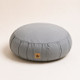 Grey Neuhaus Zen Comfort Zafu meditation cushion with organic cotton cover and buckwheat hull filling on a warm off-white studio background.
