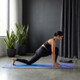 Woman practicing yoga lunge stretch on a mat indoors in a minimalist home workout yoga setup