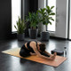 Woman practicing yoga stretch on a mat indoors in a minimalist home workout yoga setup