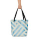 Minimalist blue patterned tote bag with black handles on a plain background