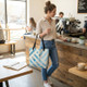 Woman carrying blue marble tote bag in a café setting for everyday use and travel