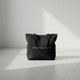 minimalist black tote bag on bench in a clean indoor setting wit Neuhaus Zen Branding