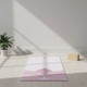 White suede TPE yoga mat laid flat in a bright home yoga space with yoga blocks nearby