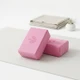 Blush pink EVA yoga blocks on a white yoga mat for stretching, support and home practice