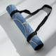 Rolled blue Art Deco yoga mat secured with a black carry strap