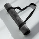 Rolled Geo Zen yoga mat secured with a black carry strap for easy transport