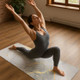 Woman practising yoga on a white and grey marble-effect yoga mat with gold detailing