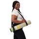 Woman carrying a rolled neutral retro stripe yoga mat with shoulder strap