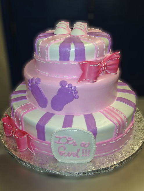Approximate Servings 80. Sizes: 7", 10" & 14". Three tiered baby feet decorated cake accented with sugar bows and baby booties.