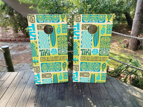 cornhole boards featuring tiki text, fish, surfboards and a totem pole