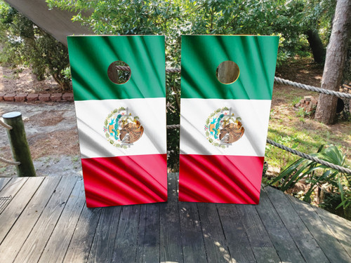 Cornhole board wraps featuring the traditional Mexican flag design with vibrant green, white, and red stripes and the national coat of arms centered, displayed outdoors on a wooden deck.