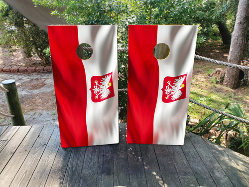 Cornhole board wraps featuring the red and white Polish flag with a flowing fabric effect and centered white eagle coat of arms, displayed on wooden boards in an outdoor setting.