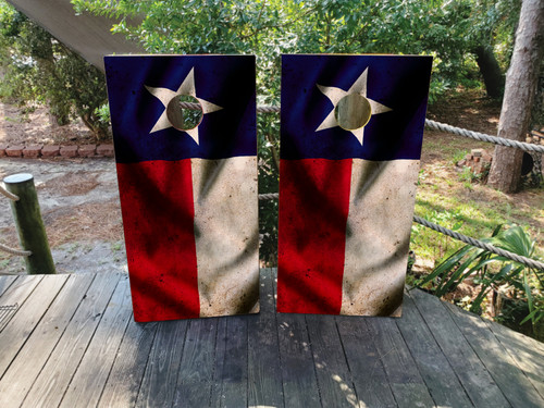 Cornhole boards featuring a distressed waving TX flag