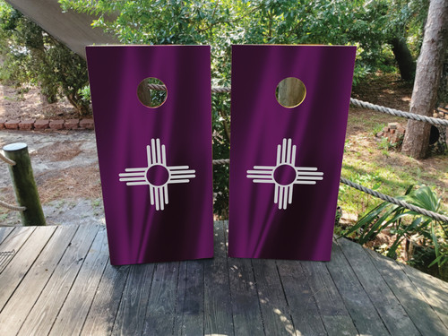 “Regulation 24×48″ professional cornhole boards featuring New Mexico purple Zia sun symbol on rustic woodgrain wrap laminated and printed on clear-coated ¾″ birch”