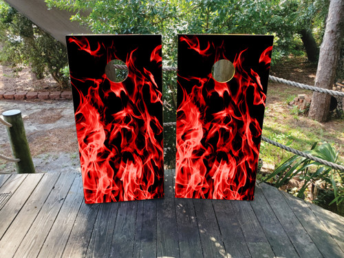 A cornhole set featuring red flames on a black background