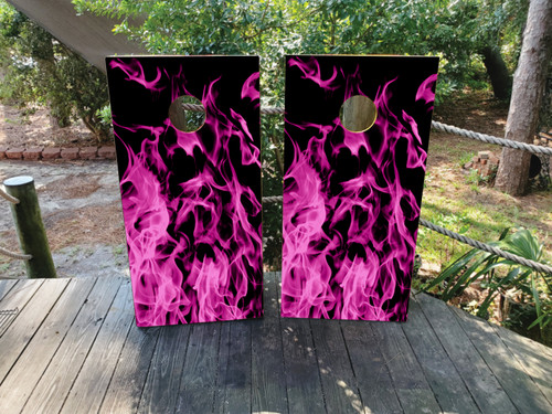 A cornhole set featuring pink flames on a black background