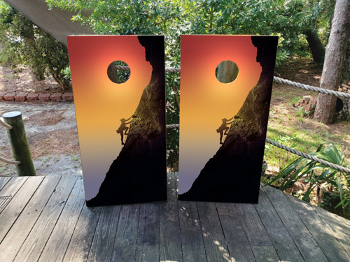 "Mountain Climbing Cornhole Boards featuring climber silhouette on rugged mountain landscape with scenic outdoor adventure theme"