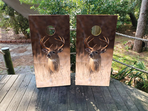 Cornhole boards with a white tail deer in the tall grass