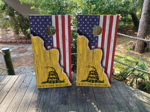Regulation 24×48″ tournament-grade cornhole boards with Gadsden “Don’t Tread On Me” snake flag overlay and rustic American flag woodgrain wrap printed on clear-coated birch