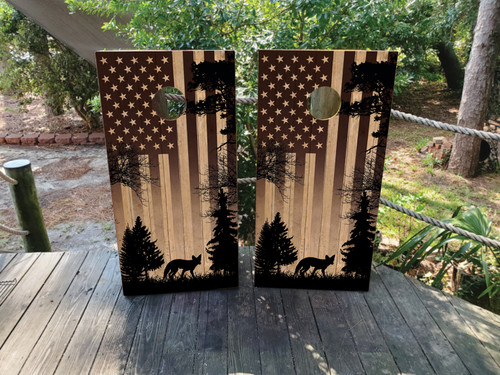 Cornhole wraps featuring a USA American flag and a coyote in the woods