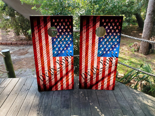 "We The People USA American Flag Cornhole Boards featuring rustic American flag design with ‘We The People’ script in patriotic theme"