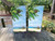 A scenic beach with a beach hut in the distance on a set of cornhole boards