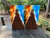 Pair of cornhole boards featuring a dynamic fire and ice split design at the top, transitioning into a dark woodgrain base with a vertical triangle spotlight effect.