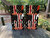 Pair of cornhole boards featuring a distressed American flag with a thin red line and a skull design, overlaid with the bold text “FIRST IN” at the top and “LAST OUT” at the bottom in bright orange.