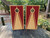 Cornhole boards featuring a natural wood grain and red design