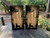 Two cornhole wraps with a rustic woodgrain background featuring black silhouettes of deer standing among trees, with bowling arrows descending from the top, creating a hunting and nature-inspired design."