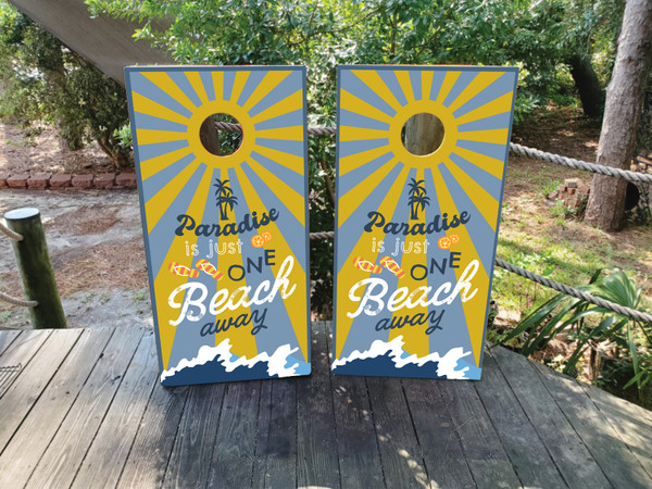 "Paradise is Just One Beach Away Cornhole Boards featuring tropical beach scene with palm trees, ocean waves, and relaxing coastal design"