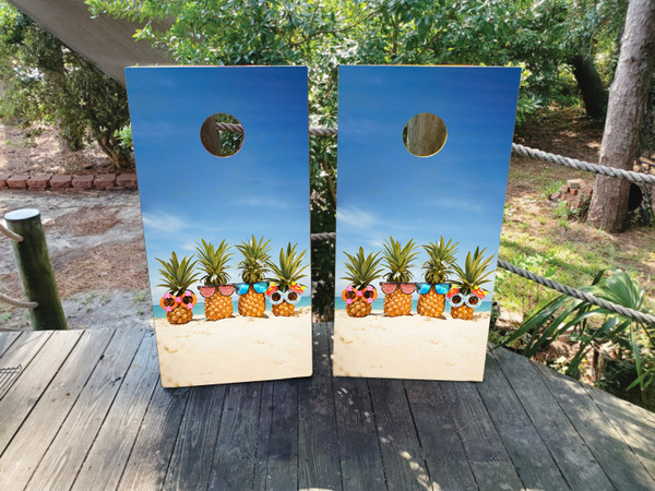 cornhole boards featuring a pineapples on the beach